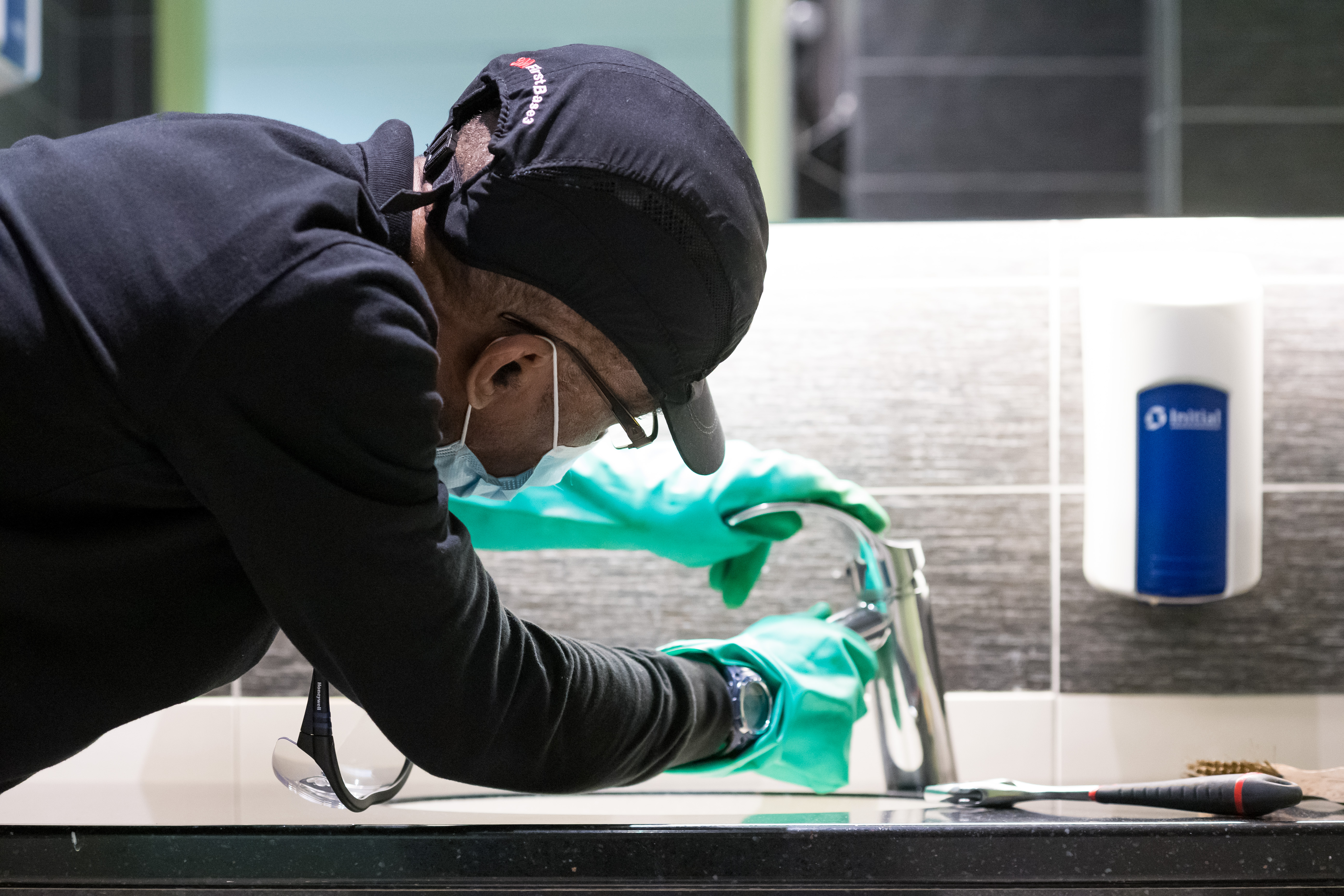 IMAGE TRAVAILLE ESEIS Technicien de nettoyage professionnel désinfectant une surface avec des gants verts